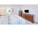 Inviting bedroom featuring wood dressers and a serene view of the en-suite bathroom at 25324 Aysen Dr, Punta Gorda, FL 33983