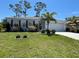Charming single-story home with a well-manicured lawn and colorful landscaping at 25324 Aysen Dr, Punta Gorda, FL 33983