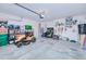 Spacious garage equipped with a lawn mower, storage shelves, and ample space for tools at 25324 Aysen Dr, Punta Gorda, FL 33983
