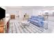 Open-concept living room featuring tile floors, a blue sofa, and seamless access to the kitchen area at 25324 Aysen Dr, Punta Gorda, FL 33983