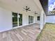 A covered back porch with wood-look tile and two ceiling fans at 2743 Begonia Ter, North Port, FL 34286