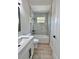 Bathroom featuring gray marble shower with black hardware and white vanity at 2743 Begonia Ter, North Port, FL 34286