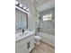 Bathroom featuring gray marble shower with black hardware and white vanity at 2743 Begonia Ter, North Port, FL 34286