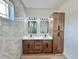 Bathroom with double sinks, granite countertop, tile accents, and spacious cabinets at 2743 Begonia Ter, North Port, FL 34286