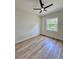 This bedroom has wood-look floors, a ceiling fan, and a window with wooded view at 2743 Begonia Ter, North Port, FL 34286