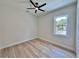 This bedroom has wood-look floors, ceiling fan, and a window with a view at 2743 Begonia Ter, North Port, FL 34286