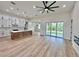 Open-concept living room featuring a modern kitchen and large sliding doors to the backyard at 2743 Begonia Ter, North Port, FL 34286