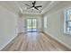 Main bedroom featuring a tray ceiling, large windows, and sliding glass door to the backyard at 2743 Begonia Ter, North Port, FL 34286