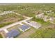 Aerial view of three modern homes surrounded by lush greenery in a serene neighborhood at 27438 Corinthian Dr, Punta Gorda, FL 33955
