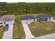 Aerial view of three modern homes with well-maintained lawns and long driveways at 27438 Corinthian Dr, Punta Gorda, FL 33955