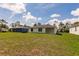 Spacious backyard showcasing the home's rear exterior, ample green space, and mature trees at 27438 Corinthian Dr, Punta Gorda, FL 33955