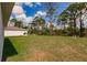A large backyard featuring green grass and tall trees providing privacy to the property at 27438 Corinthian Dr, Punta Gorda, FL 33955