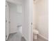 Bathroom features wood look floors, white toilet, and doorway to another room at 27438 Corinthian Dr, Punta Gorda, FL 33955