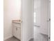 Powder room with a granite vanity, white cabinets and door leading to the bedroom at 27438 Corinthian Dr, Punta Gorda, FL 33955