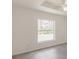 Bright bedroom features wood look floors and a window overlooking a beautiful green space at 27438 Corinthian Dr, Punta Gorda, FL 33955
