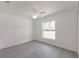Bright bedroom with wood look floors, ceiling fan, and window overlooking green space at 27438 Corinthian Dr, Punta Gorda, FL 33955