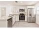Kitchen featuring stainless appliances, granite countertops, and white cabinets, open to other rooms at 27438 Corinthian Dr, Punta Gorda, FL 33955