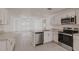 Bright kitchen with white cabinets, stainless steel appliances, and granite countertops at 27438 Corinthian Dr, Punta Gorda, FL 33955