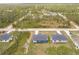 An aerial view of single-Gathering homes surrounded by lush green trees in a serene neighborhood at 27444 Corinthian Dr, Punta Gorda, FL 33955