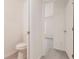 Clean, white toilet in a well-lit bathroom with light-colored flooring and a view into a bedroom at 27444 Corinthian Dr, Punta Gorda, FL 33955
