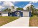Charming one-story home with a well-maintained lawn, a paved driveway, and an attached garage at 27444 Corinthian Dr, Punta Gorda, FL 33955