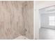 Luxurious shower with marble-look tiling and modern fixtures, adjacent to a bright, airy bedroom at 27444 Corinthian Dr, Punta Gorda, FL 33955
