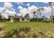 Spacious backyard featuring lush grass and the home's rear facade with a covered patio at 27456 Corinthian Dr, Punta Gorda, FL 33955