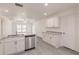 Open-concept kitchen featuring granite countertops and white cabinetry, connected to a spacious, bright living area at 27456 Corinthian Dr, Punta Gorda, FL 33955