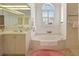 Bright bathroom with dual vanities, a large soaking tub, and a separate glass block shower at 2833 La Mancha Ct, Punta Gorda, FL 33950