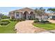 Lovely single-story home features a barrel tile roof, arched entryway, and paver driveway with lush landscaping at 2833 La Mancha Ct, Punta Gorda, FL 33950