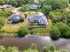 Aerial view of the home featuring a screened pool, landscaping, and waterfront access at 3027 Ridgewood Dr, North Port, FL 34287
