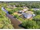 Aerial view of a home with screened pool and landscaping backing onto a river in a tropical neighborhood at 3027 Ridgewood Dr, North Port, FL 34287