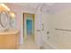 A bathroom with walk-in shower, grab bars, vanity, and doorway access at 3027 Ridgewood Dr, North Port, FL 34287