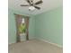 A minimalist bedroom featuring carpet, a ceiling fan, and a window with a view of the outside at 3027 Ridgewood Dr, North Port, FL 34287