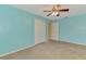 An empty bedroom featuring carpet, a ceiling fan, a closet, and an entrance to another room at 3027 Ridgewood Dr, North Port, FL 34287