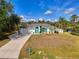 Charming single-story home with a manicured front lawn and a bright, turquoise-accented facade at 3027 Ridgewood Dr, North Port, FL 34287