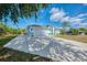 Bright home featuring a pristine driveway, clean white exterior, palm trees, and elegant, eye-catching turquoise accents at 3027 Ridgewood Dr, North Port, FL 34287