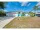 Charming home with a well-manicured lawn, a two car garage, and turquoise trim at 3027 Ridgewood Dr, North Port, FL 34287