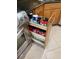 Pull out spice rack cabinet with wooden finish and various spices next to a stainless steel oven at 3027 Ridgewood Dr, North Port, FL 34287