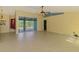 Open-concept living area with tile flooring, ceiling fan and large glass doors leading to outdoor pool at 3027 Ridgewood Dr, North Port, FL 34287