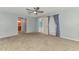 A main bedroom featuring an ensuite bathroom, ceiling fan, and carpet flooring at 3027 Ridgewood Dr, North Port, FL 34287