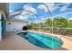 Screened-in pool with clear blue water, offering a private outdoor oasis surrounded by palm trees at 3027 Ridgewood Dr, North Port, FL 34287