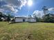 The back exterior of a white single-story home on a large lot with green grass at 3045 Montgomery Dr, Port Charlotte, FL 33981
