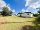 Back exterior of a white single-story home on a large lot with green grass at 3045 Montgomery Dr, Port Charlotte, FL 33981