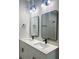 Bathroom featuring a double vanity with modern fixtures, sleek mirrors and a tiled shower at 3045 Montgomery Dr, Port Charlotte, FL 33981