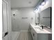 Bright bathroom featuring a double vanity with modern fixtures, sleek mirrors and a tiled shower at 3045 Montgomery Dr, Port Charlotte, FL 33981