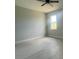 This bedroom features a ceiling fan, light gray walls, light gray floors, and a window that provides ample natural light at 3045 Montgomery Dr, Port Charlotte, FL 33981