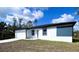 Single-story home with a manicured lawn, white exterior, black trim, and a two-car garage at 3045 Montgomery Dr, Port Charlotte, FL 33981