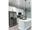 Chic kitchen with white cabinets, stainless steel appliances, a stylish island, and modern pendant lighting at 3045 Montgomery Dr, Port Charlotte, FL 33981