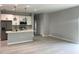 Light and airy open floor plan with modern kitchen, island, stainless appliances, and wood look flooring at 3045 Montgomery Dr, Port Charlotte, FL 33981